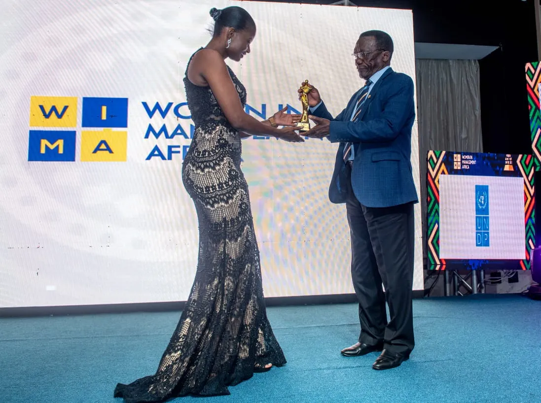 Jónia Presado receiving WIMA trophy from senior gentleman